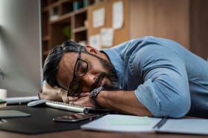 man with narcolepsy sleeping at the office