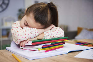 Tired and bored child sleeping on books