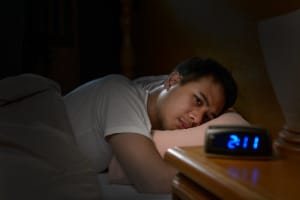 Depressed man suffering from anxiety lying in bed