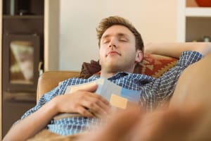 Young man napping on his couch at home in the living room