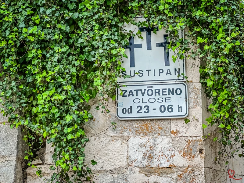 Park closing time sign surrounded by ivy.