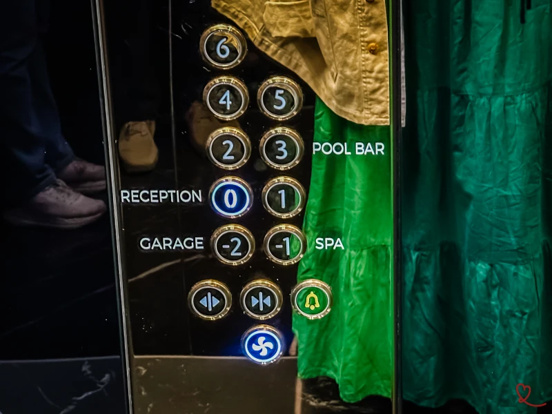 Painel de controlo do elevador com botões para diferentes pisos e serviços.