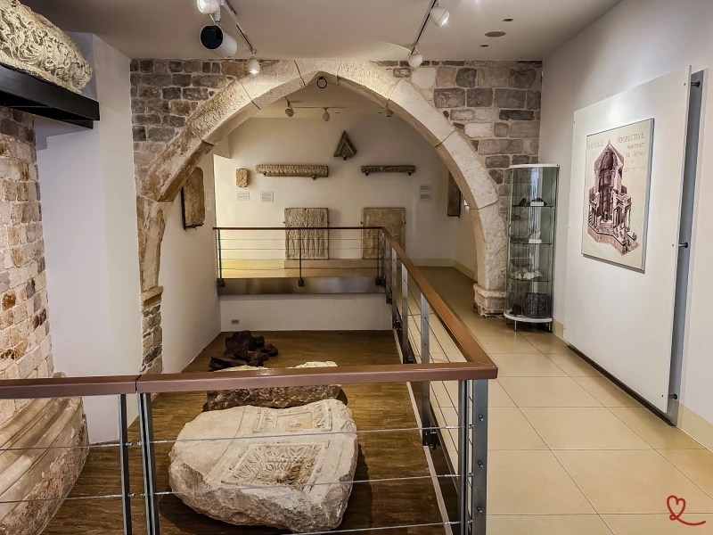 Sala espositiva con sculture antiche e elementi architettonici in pietra.