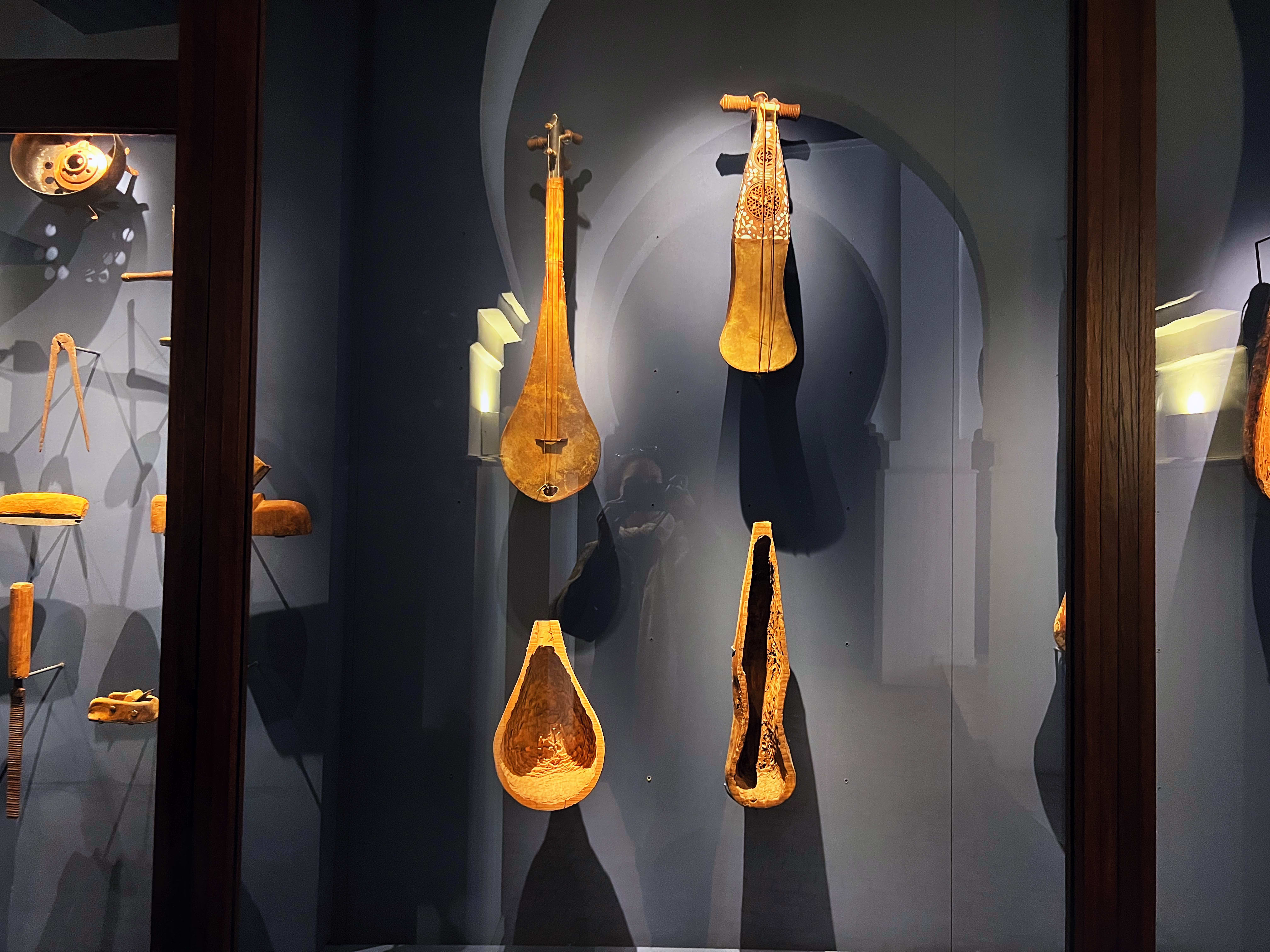 Instruments de musique anciens exposés dans une vitrine sombre