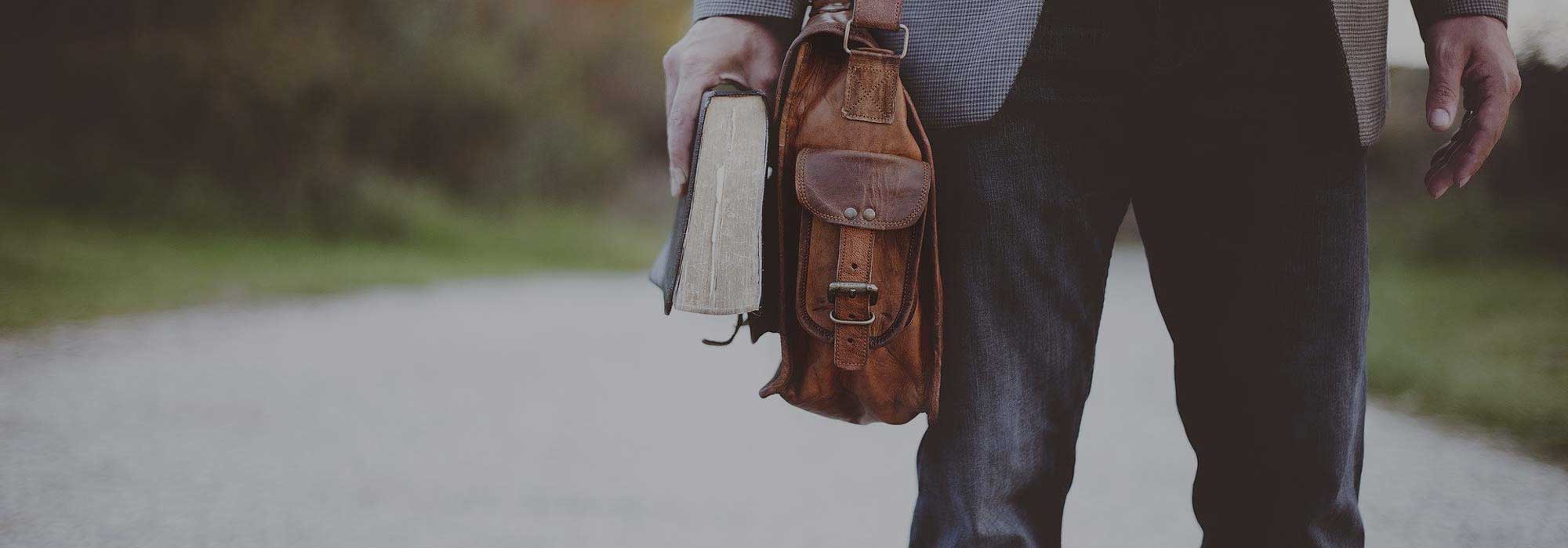 man with bag and book