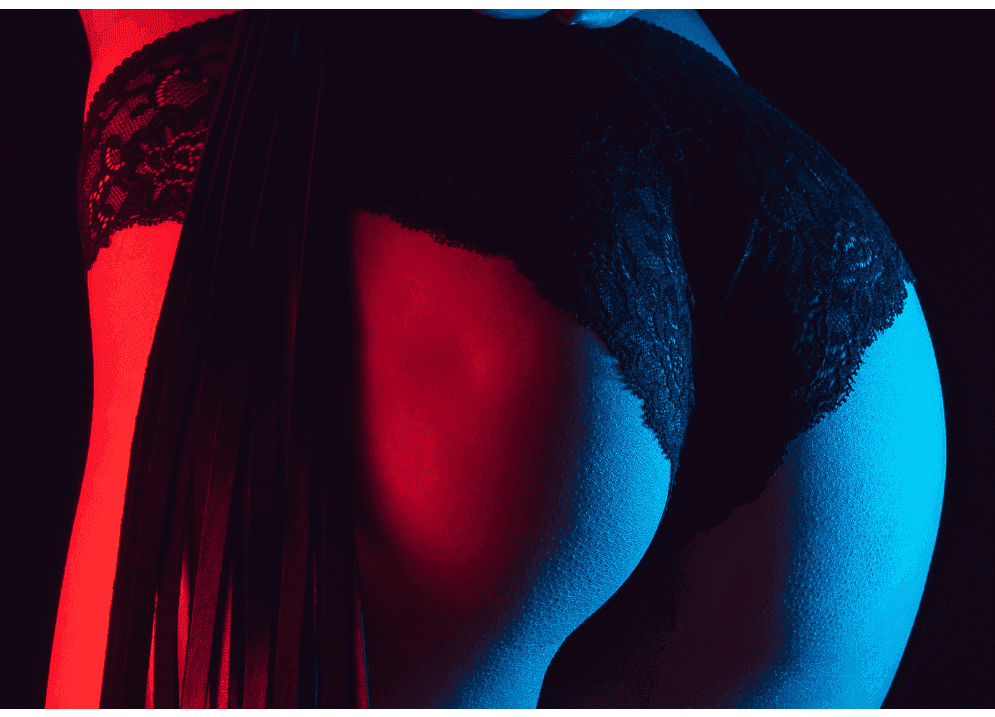 Female bottom in lacy black knickers with a red light shining on one side