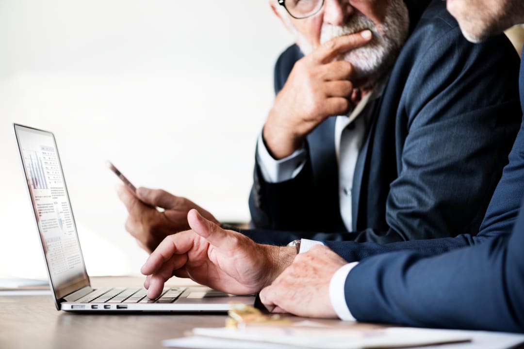 Due professionisti consultano un report su un laptop durante una riunione di lavoro