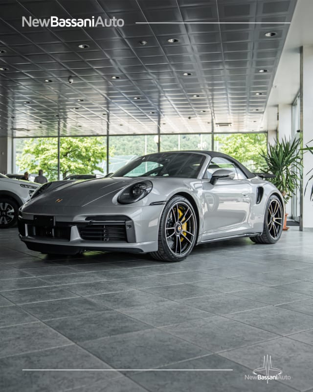 Porsche 911 Cabriolet grigia con le pinze dei freni gialle, esposta nel salone di New Bassani Auto