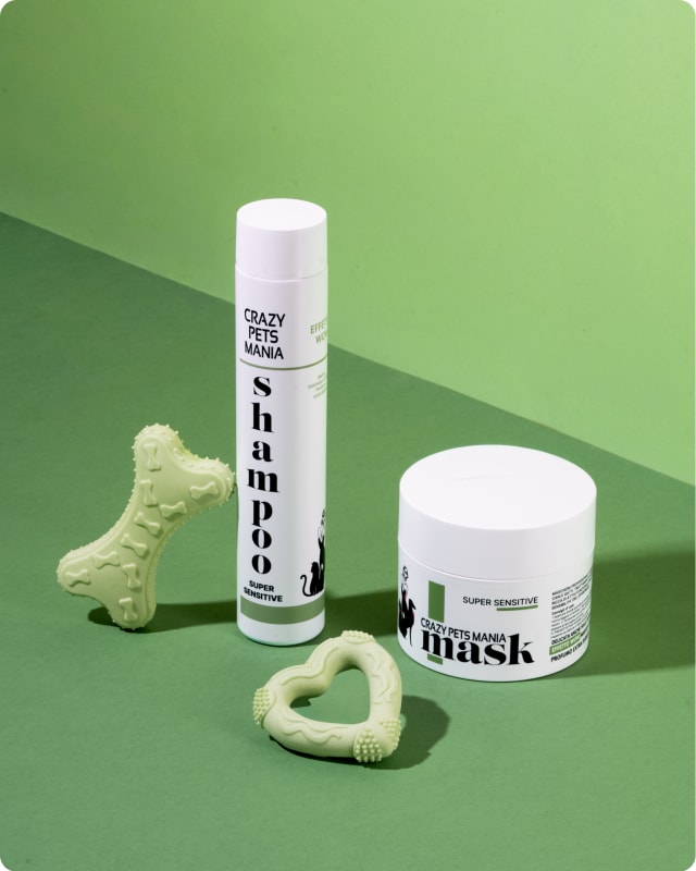 Shampoo e maschera Crazy Pets Mania Super Sensitive su fondo verde, affiancati da due giochi in silicone a forma di osso e di cuore