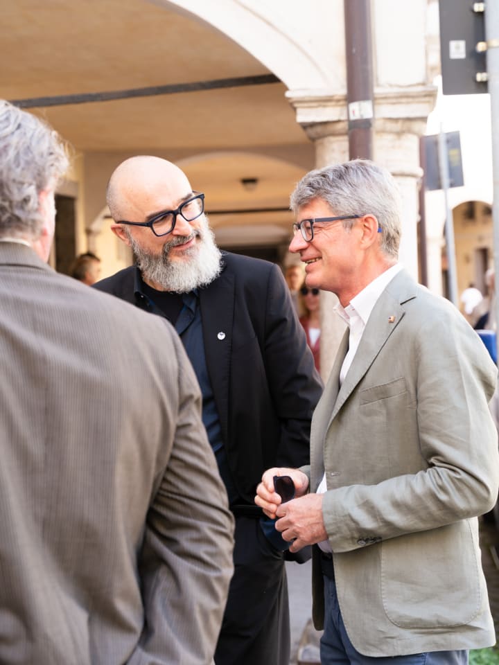 Ospiti che conversano sotto i portici, all’esterno della sede dell’evento