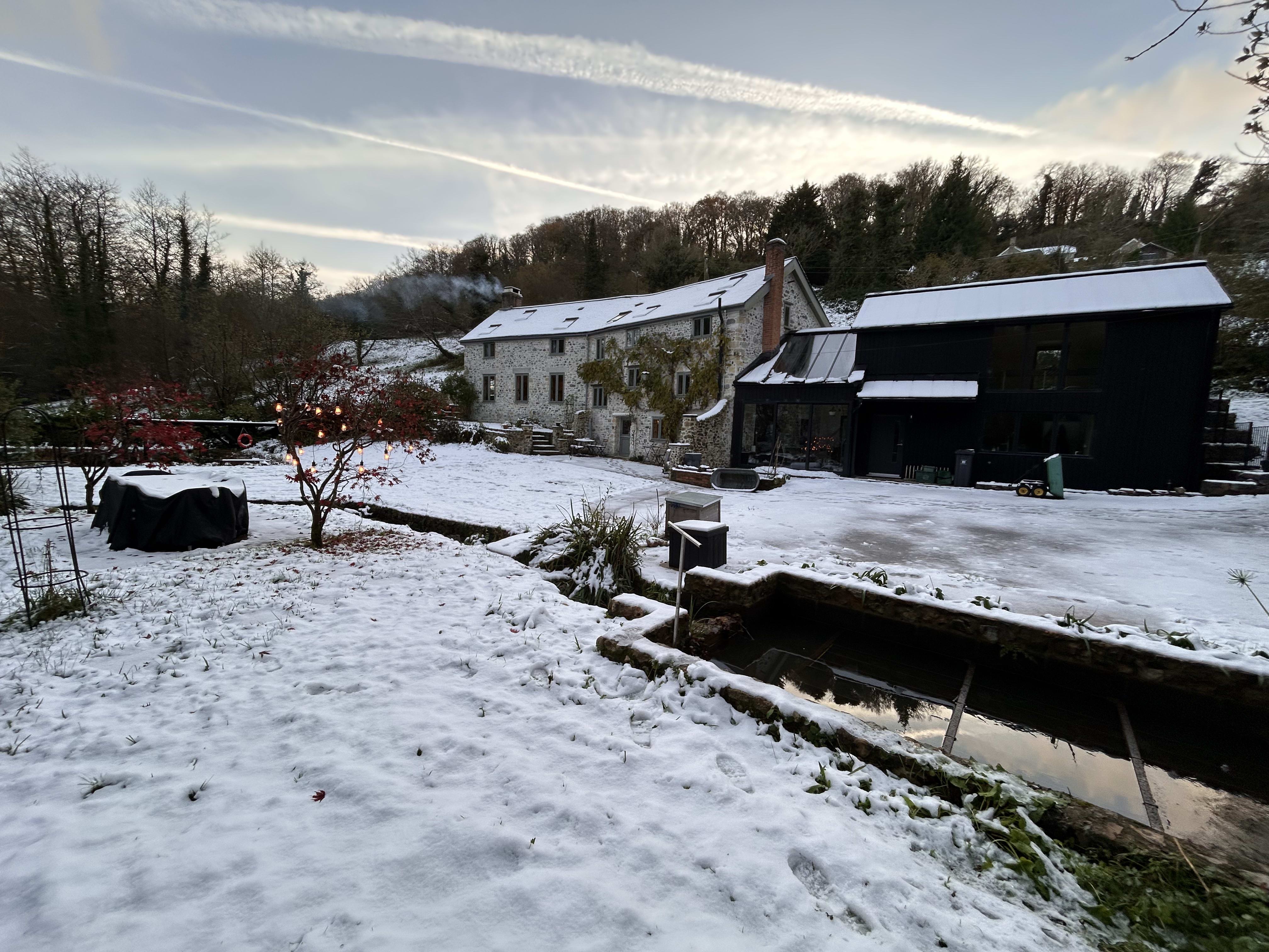 Hot tub fire stoked with wood logs in the Hole Mill garden, Branscombe Devon