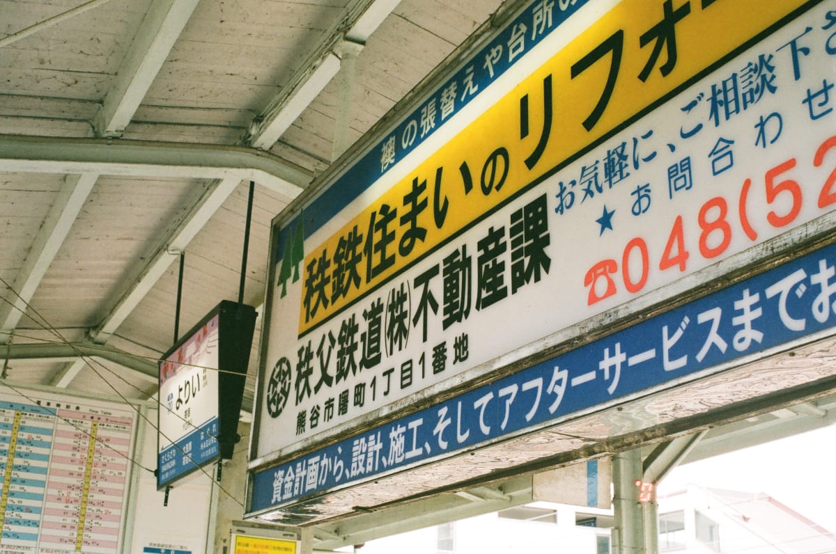 a real estate agent signboard, taken at the train station. would I want to live there? probably not.