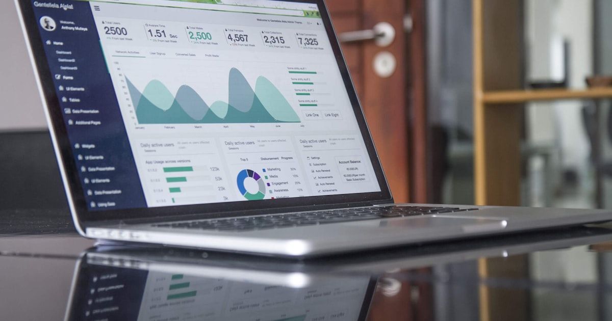Business professional viewing CRM dashboard on laptop with analytics and automation workflows displayed on screen