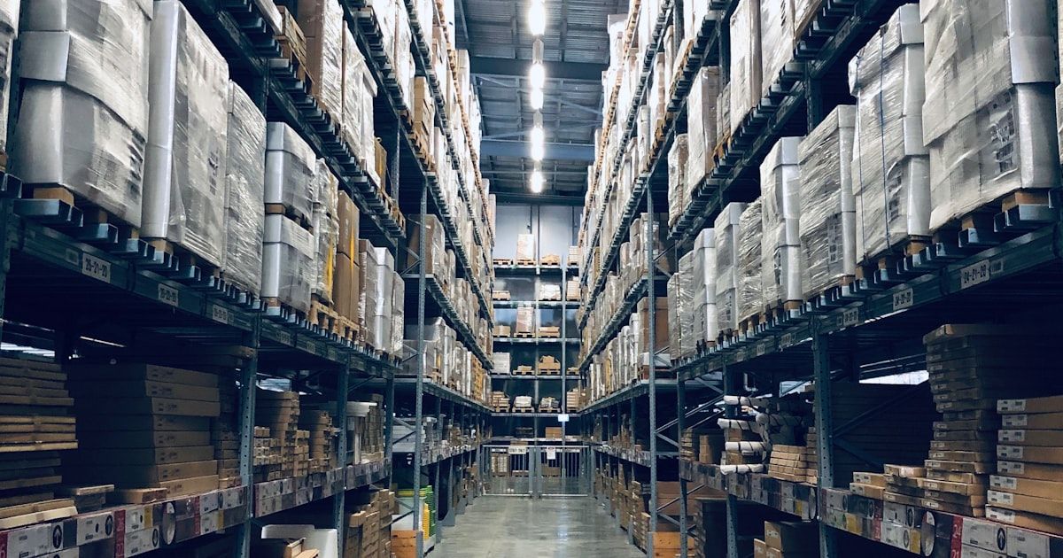 Warehouse worker processing a customer return, scanning items against a tablet — representing the returns receipt moment where refund records diverge from portal approvals