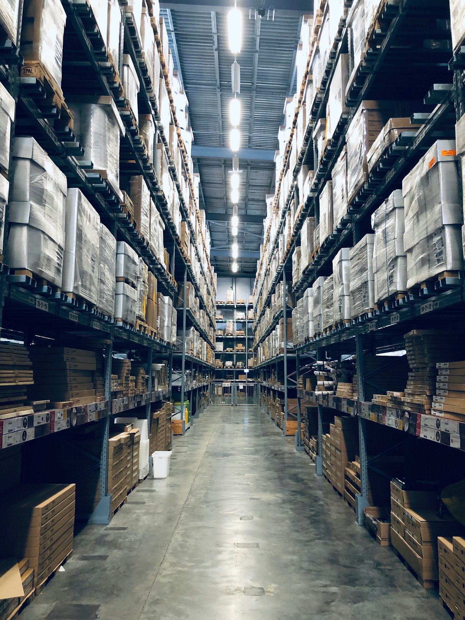 Workers checking inventory levels on warehouse shelves during seasonal peak period