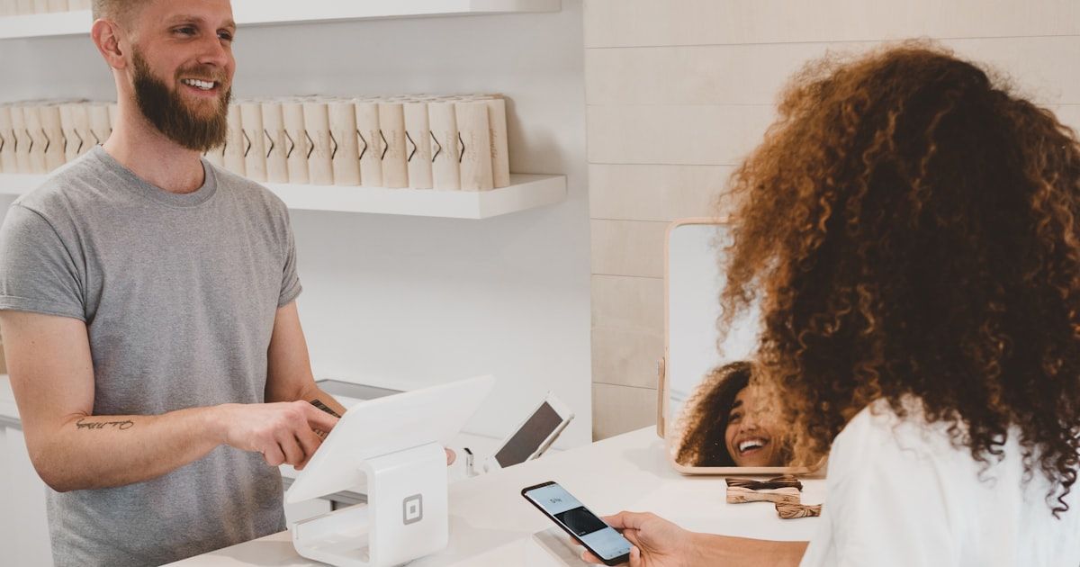 A retail checkout counter with a POS terminal and customer loyalty cards beside it, illustrating fragmented customer data across disconnected systems