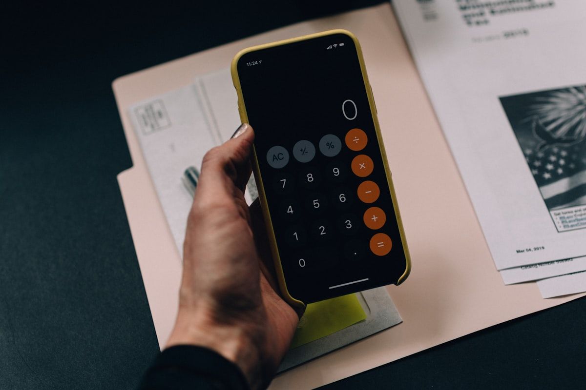 A modern finance workplace featuring a laptop with a complex accounting grid, a clean digital calculator, and neat printouts, symbolizing organized back-office finance and accounting operations.