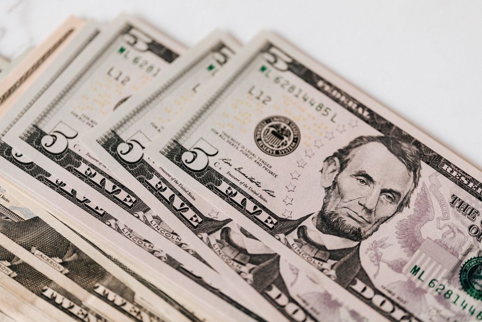 Top view of stack of US dollar banknotes placed together on white background