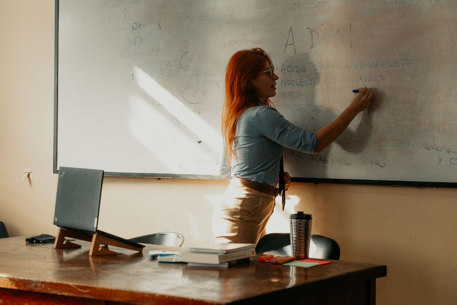 A teacher instructs at a whiteboard inside a Buenos Aires classroom, focusing on lesson planning.
