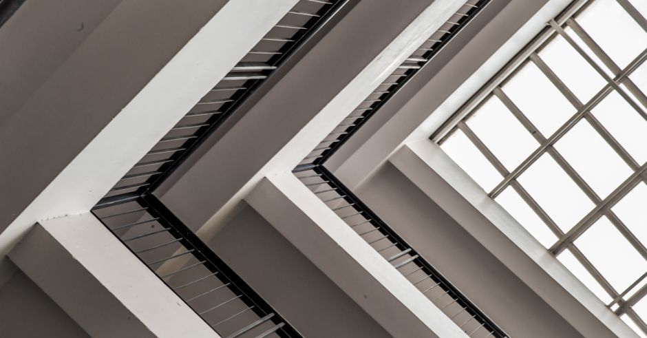 A contemporary architectural ceiling showcasing geometric lines, steel, and glass elements.