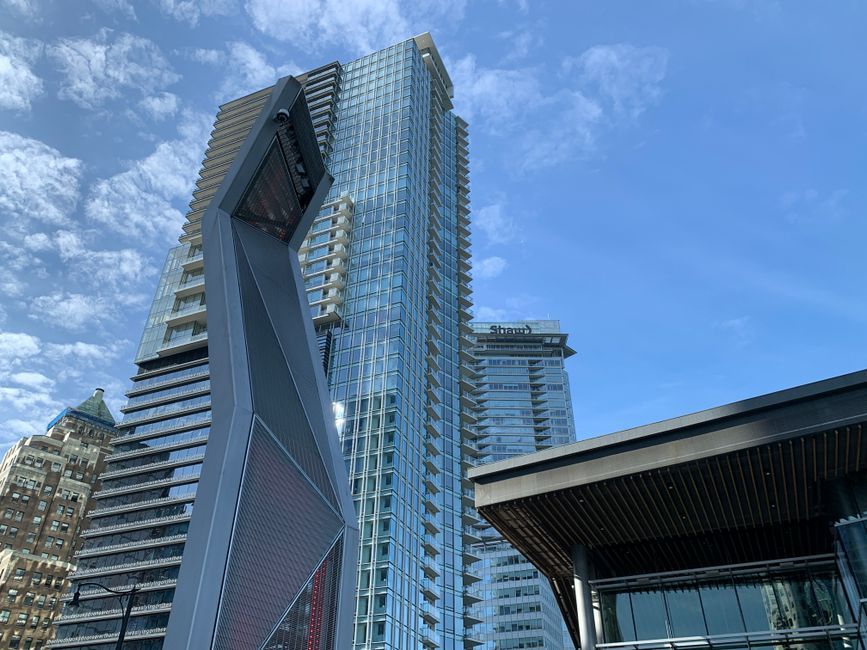 A low angle view of modern skyscrapers against a blue sky in downtown Vancouver.