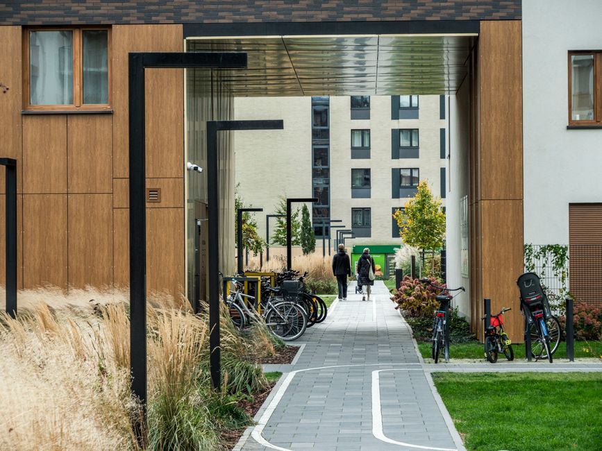 A serene urban courtyard with bicycles and walking paths, framed by modern architecture.