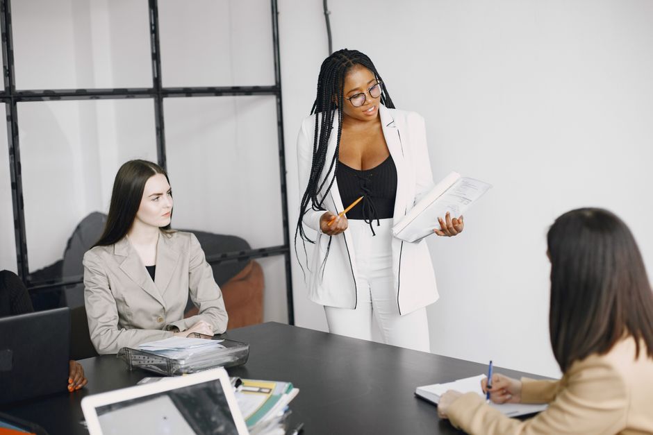 A diverse team of women engaged in a collaborative business meeting in a modern office setting.