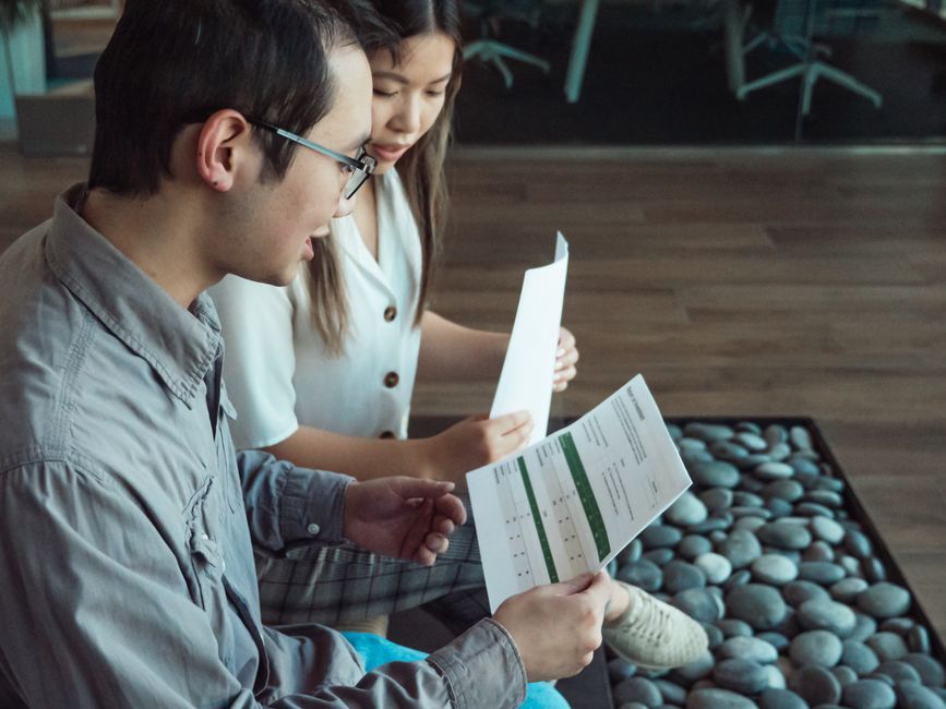 Two professionals discussing documents in a modern office setting.
