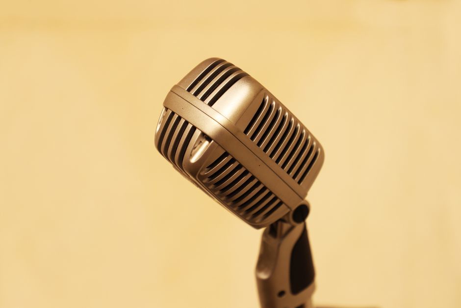 Close-up of a vintage microphone with a warm tone, perfect for music and retro-themed designs.