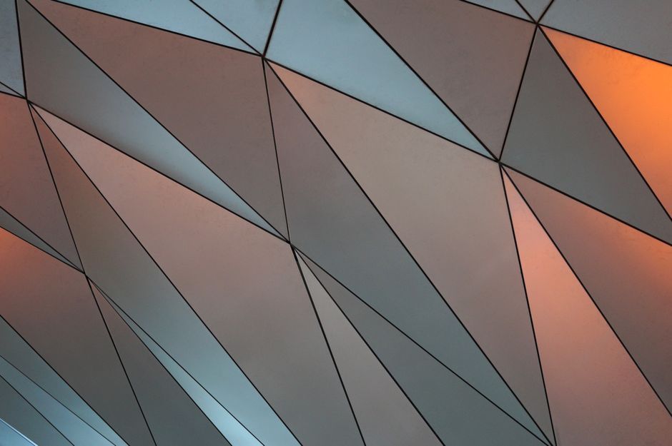 Abstract geometric design with muted tones and dynamic triangular shapes.