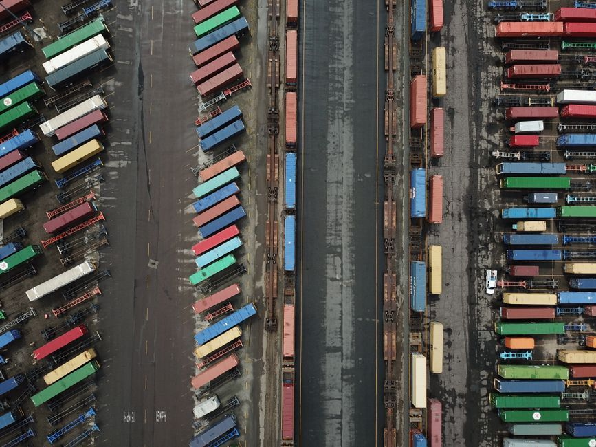 Drone shot of vibrant shipping containers in an industrial area.