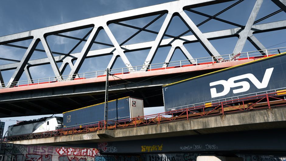 A sleek railway bridge in Hamburg, Germany with freight trains below, showcasing modern infrastructure.
