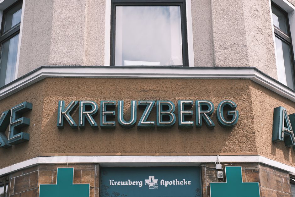 Close-up of a pharmacy facade with signage in Kreuzberg, Berlin. Urban architecture and typography.