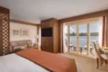Elegant cabin aboard Steigenberger Senator Nile Cruise – cozy bedding and large windows facing the Nile