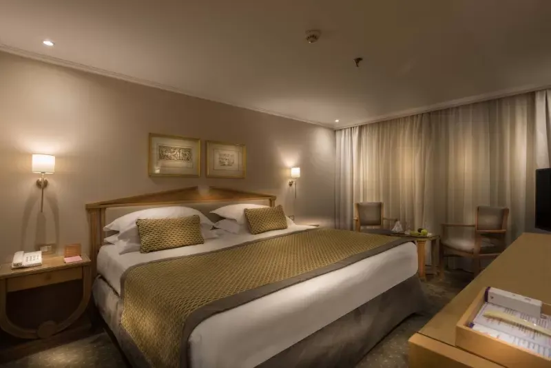 Luxurious cabin aboard Steigenberger Royale Nile Cruise – plush bedding and panoramic windows overlooking the river