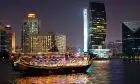 Dhow boat dinner cruise on Dubai Marina at night, enjoying city lights and traditional Arabian cuisine.