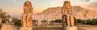 Colossi of Memnon in Luxor, Egypt, featuring two massive stone statues of Pharaoh Amenhotep III