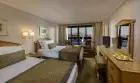 Luxurious cabin aboard Steigenberger Royale Nile Cruise – plush bedding and panoramic windows overlooking the river
