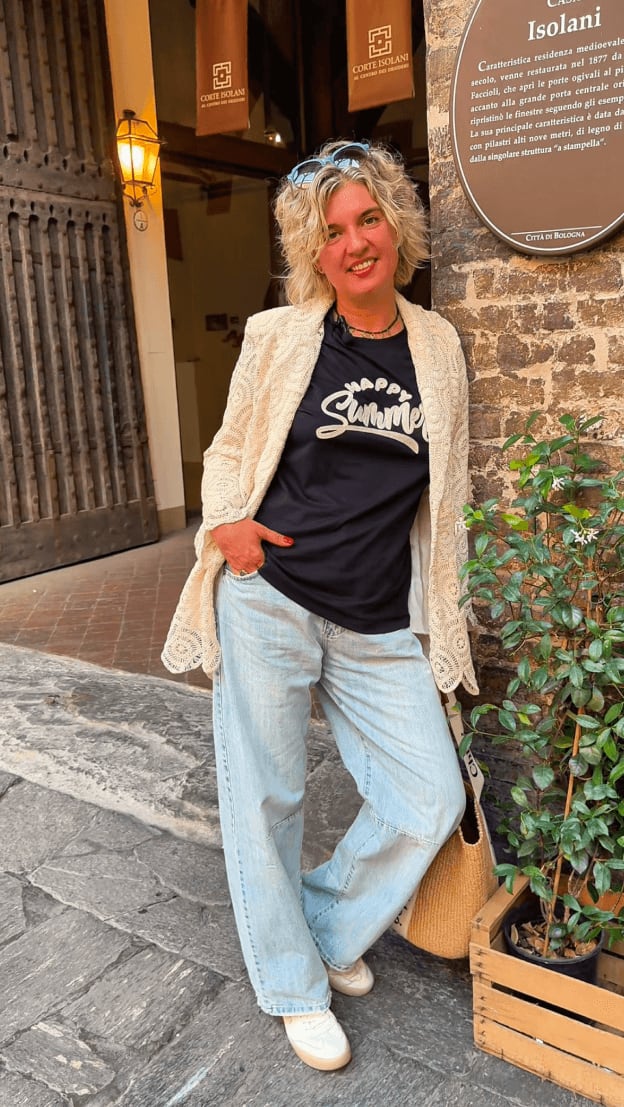 Donna con outfit casual davanti Corte Isolani Bologna. Content creation per brand fashion e SMM.