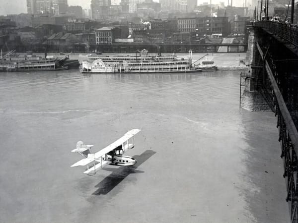 Biplane flies under the Eads Bridge