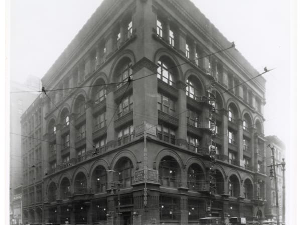 Mercantile Library Building: The Mercantile Library Building at Broadway and Locust in the 1920s, with signs for the First National Bank and the St. Louis Union Trust Company at the corner and a spiral fire escape on the Locust side.