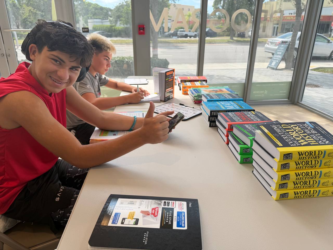 Two Pinecrest microschool students studying with textbooks at the Las Rocas study tables