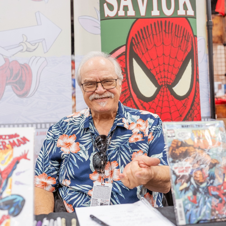 a comic author sitting at a booth