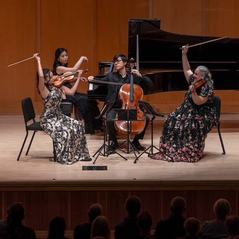 people on stage playing string instruments 