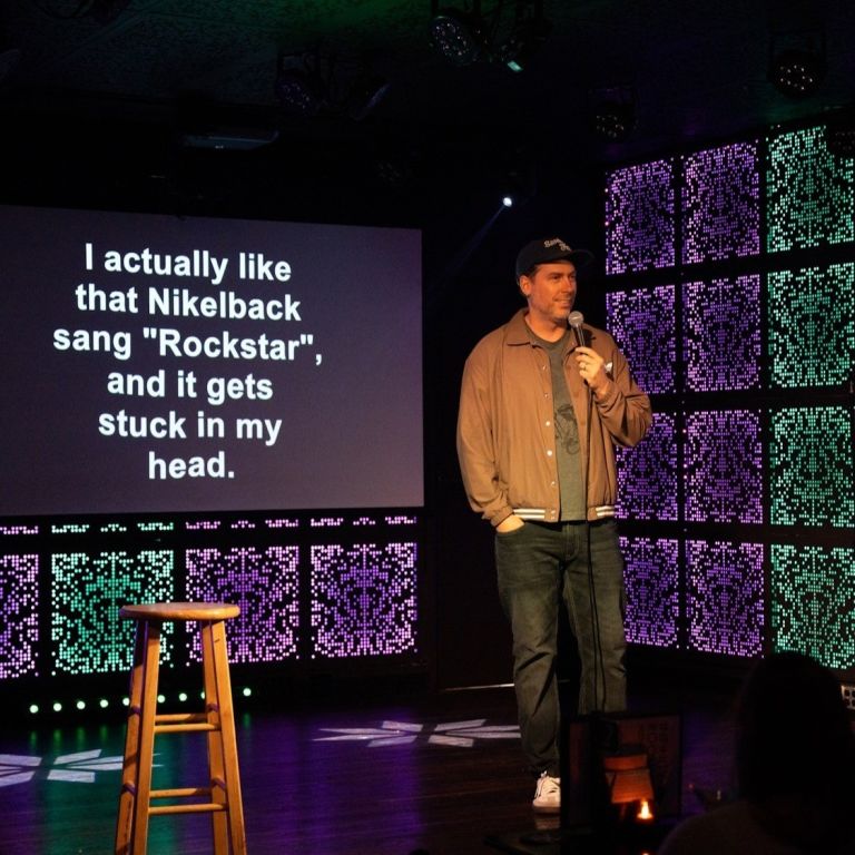 person on stage speaking into a microphone