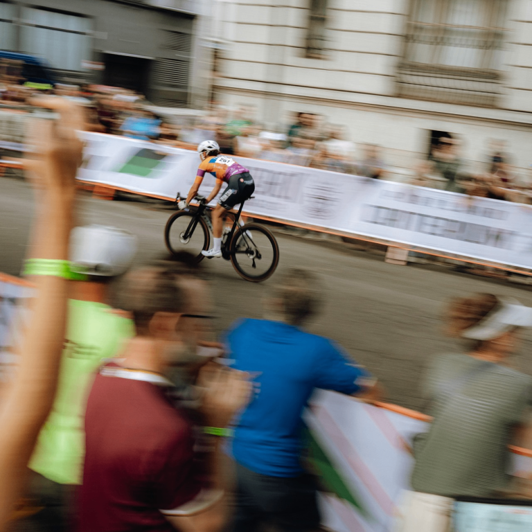 a racer on a bike speeds past spectators