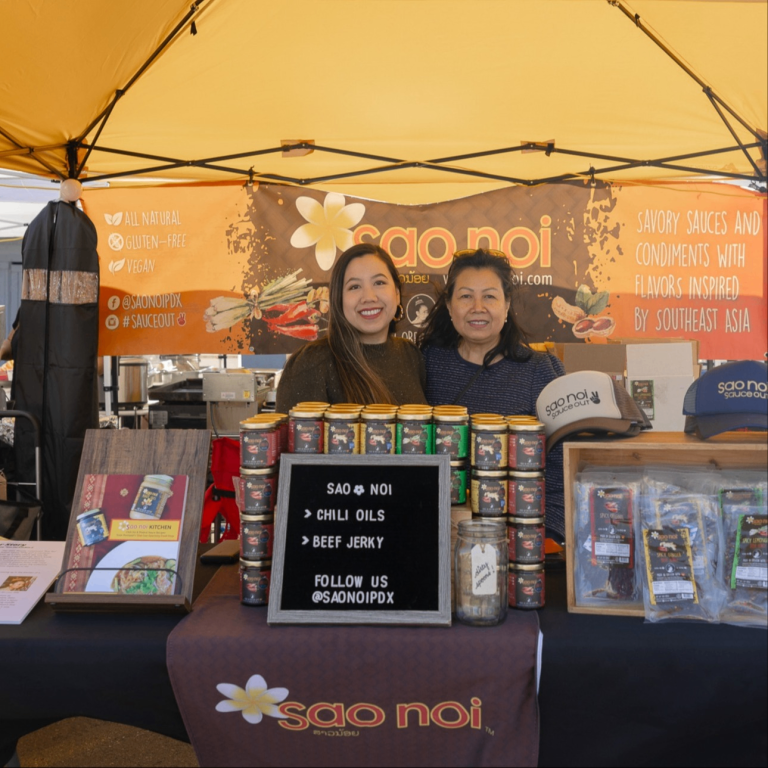 people selling sauces at a booth in a market