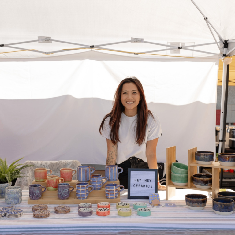 a person selling ceramics at a market booth