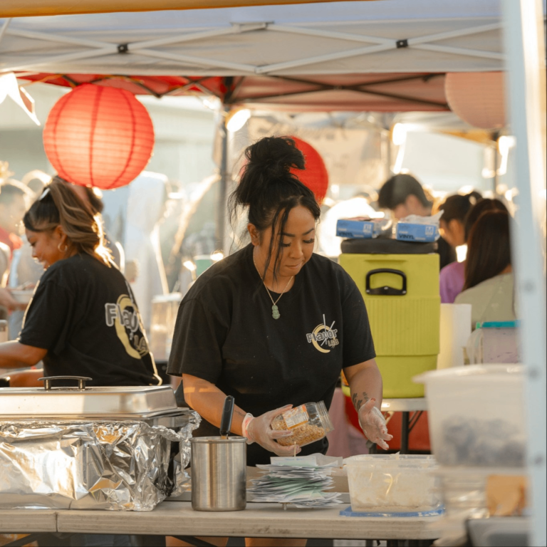 a person preparing food at an open air market