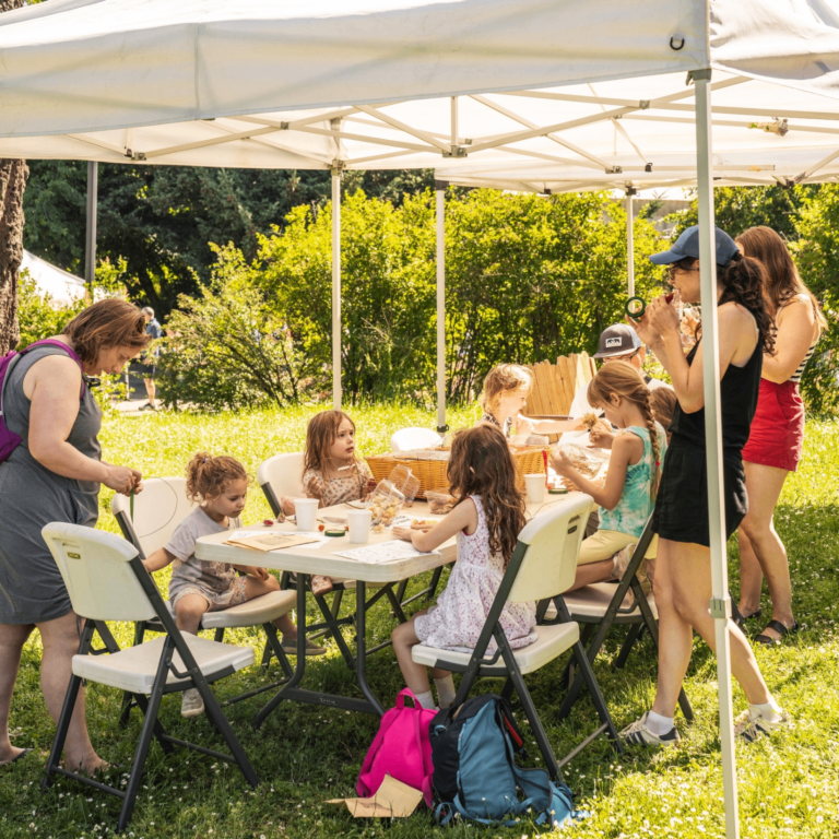 people eating at a table under a canopy